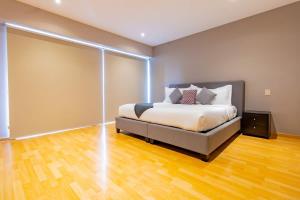 Un dormitorio con una cama y suelo de madera. en Capitalia Luxe 1BR Stay with Top Features, en Ciudad de México