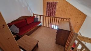 圣索林达尔沃Duplex avec piscine - Les Chalets de Saint Sorlin的一间带红色沙发的客厅和楼梯