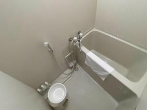 ein Badezimmer mit einem WC neben einer Badewanne in der Unterkunft ゲストハウスひわまり セルフチェックイン 瓦町すぐ in Takamatsu
