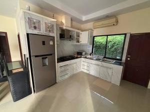 a kitchen with a stainless steel refrigerator and a window at Unique Paradise Resort in Ban Map Fakthong
