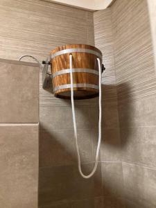 a wooden bucket on the wall of a bathroom at Ceglédi Apartmanpark & Kemping in Cegléd