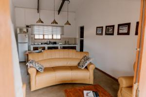 a living room with a couch and a kitchen at Chandelier Game Lodge in Oudtshoorn