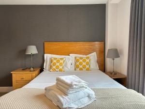 a bedroom with a bed with towels on it at The North Hill Hotel, Colchester in Colchester