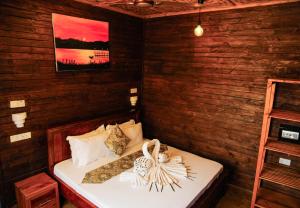 a bedroom with a bed in a room with wooden walls at Palm Cultural Village in Paje +108 photos