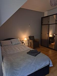 a bedroom with a large bed and a chair at Vero Apart in Marki