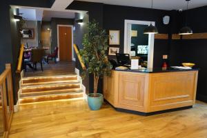 a cashier counter in a store with a potted plant at The North Hill Hotel, Colchester in Colchester