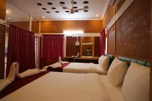 two beds in a room with red curtains at Starfalls Eco Beach Resort 