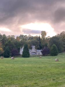 an old house in a field with hay bales at Brylach Steading in Aberlour +1 photo