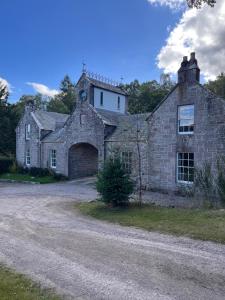 an old stone house with a large garage at Brylach Steading in Aberlour