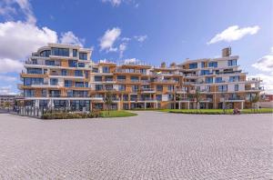 a large apartment building in front of a parking lot at Sieglinde - Apartment in der Hafenresidenz mit Balkon & Wellness in Waren