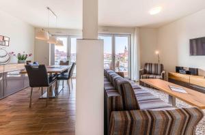 a living room with a couch and a table with chairs at Sieglinde - Apartment in der Hafenresidenz mit Balkon & Wellness in Waren