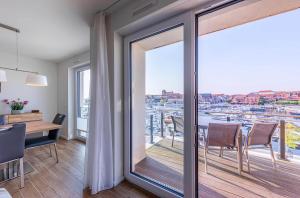 a dining room with a balcony with a table and chairs at Sieglinde - Apartment in der Hafenresidenz mit Balkon & Wellness in Waren