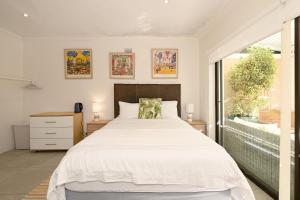 a bedroom with a large white bed and a window at Dressage Guesthouse in Sweet Valley +64 photos