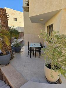 a patio with a table and chairs and potted plants at Vila Lidar in Eilat