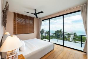 a bedroom with a bed and a large window at Tahiana Villa in Haad Tian +38 photos