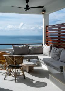 a patio with a couch and a table and the ocean at Tahiana Villa in Haad Tian