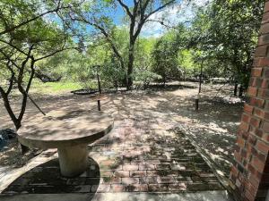 a stone bench sitting on a brick path in a park at Hello Kruger Hideaway in Marloth Park
