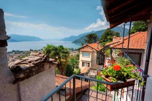 a balcony with a view of a town and a lake at Borgo Paradiso Guest House in Maccagno Inferiore