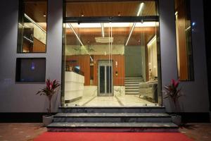 a lobby with a glass door and a red carpet at The White Castle Hotel in Mysore