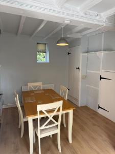 ein Esszimmer mit einem Holztisch und Stühlen in der Unterkunft Pretty 2 Bedroom Cottage in Skirmett with Parking in Turville