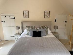 ein Schlafzimmer mit einem großen Bett mit zwei Nachttischen in der Unterkunft Pretty 2 Bedroom Cottage in Skirmett with Parking in Turville