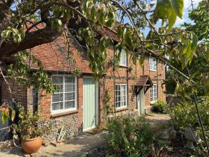 ein altes Backsteinhaus mit grüner Tür in der Unterkunft Pretty 2 Bedroom Cottage in Skirmett with Parking in Turville