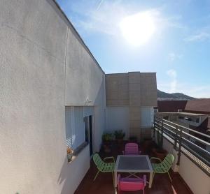 a balcony with a table and chairs on a building at Mirasierra Ático in Jaén
