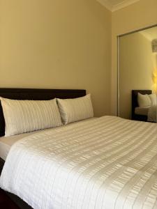 a bedroom with a large white bed with a mirror at Brand new bedroom next to train station in St Albans