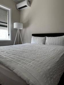 a bedroom with a large white bed and a window at Brand new bedroom next to train station in St Albans +13 photos