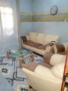 a living room with two couches and a glass table at Mifa, Appartement RDC de 2 chambres, pour famille in Dakar +1 photo