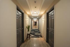 a hallway with black doors and a plant in a pot at Via Cloud 9 in Ghaziabad