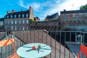 a table on a balcony in front of a building at Le Méaban - Au cœur de Vannes in Vannes
