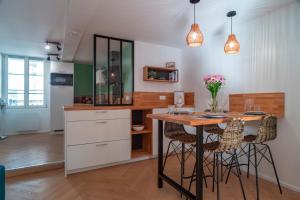 a kitchen with a table and stools in a room at Le Méaban - Au cœur de Vannes in Vannes +5 photos