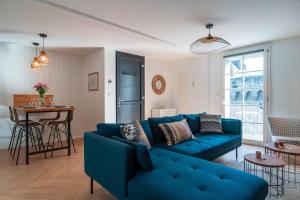 a living room with a blue couch and a table at Le Méaban - Au cœur de Vannes in Vannes