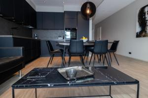 アークレイリにあるLL Properties - Stylish Apartment in Akureyriのテーブルと椅子のあるキッチンとリビングルーム