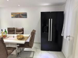 a black refrigerator in a kitchen with a table at M B Homes Lauterstein 8 in Weißenstein +10 photos