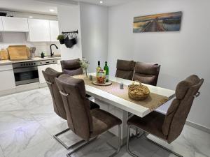 a kitchen with a white table and chairs at M B Homes Lauterstein 8 in Weißenstein