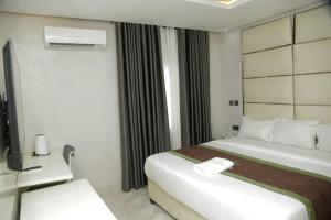 een hotelkamer met een bed en een raam bij Lushville Hotels and Suites and Apartments in Benin City