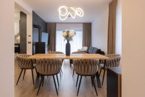 ein Esszimmer mit einem Holztisch und Stühlen in der Unterkunft Przestrony apartament z trzema sypialniami - jacuzzi i parking, kącik zabaw dla dzieci w cenie - świetny wybór dla rodzin lub grupy znajomych in Szczawnica