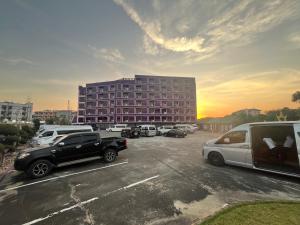 a parking lot with cars parked in front of a building at Yamadaya Apartment in Phra Nakhon Si Ayutthaya