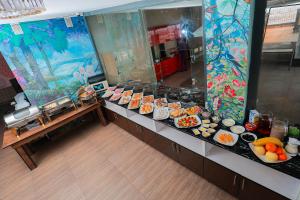Una línea de buffet con muchos tipos diferentes de comida. en Garden City, en Navoi