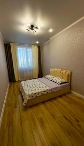 a bedroom with a bed and a ceiling fan at Family Comfort 97 in Uralsk