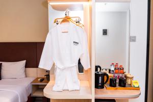 a robe on a hanger in a hotel room at Sparks Odeon Sukabumi, ARTOTEL Curated in Sukabumi