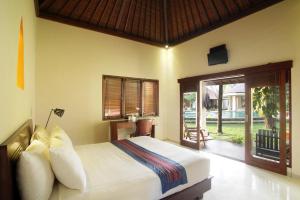 a bedroom with a bed and a sliding glass door at Puri Rinjani Bungalows in Kuta Lombok +40 photos