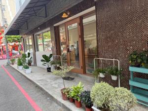 a store front with potted plants outside of it at KM Hostel in Chiayi City