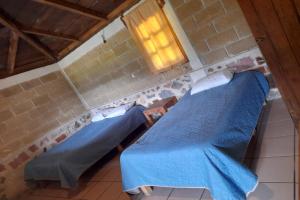 zwei Betten in einem Zimmer mit blauen Laken in der Unterkunft OYO Hotel Rincon De Texolo, Xico in Xico