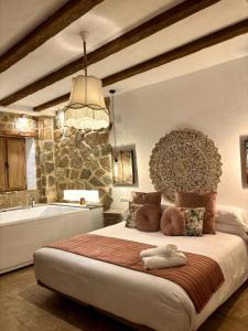 a bedroom with a large bed and a bath tub at Al Zahra Suites in Zahara de la Sierra