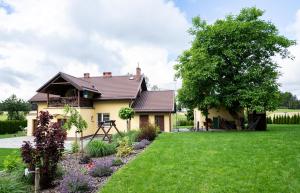a house with a garden in front of it at Apartament w lesie in Lipnica