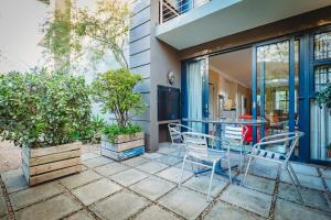 a patio with a table and chairs in front of a house at 17onWellington Apartments in George