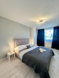 a bedroom with a large bed with blue curtains at Simcity 3 I Skyline Elegance I 3BR, private parking, sunny terrace with panoramic city view 5min walk to city square in Banská Bystrica